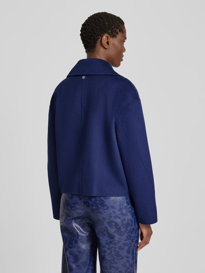 Vrouwenmodel draagt Relaxed Fit Jacke aus reiner Wolle van Marc Cain, zuiver wol, Reverskraag, 2-knoopsluiting, ruglengte maat 36: 54 cm, schouderbreedte maat 36: 53 cm, borstwijdte maat 36: 56 cm, mouwlengte maat 36: 54 cm, blauwe tinten, rechte vormen, zachte textuur, geheellichaamsaanzicht rugaanzicht