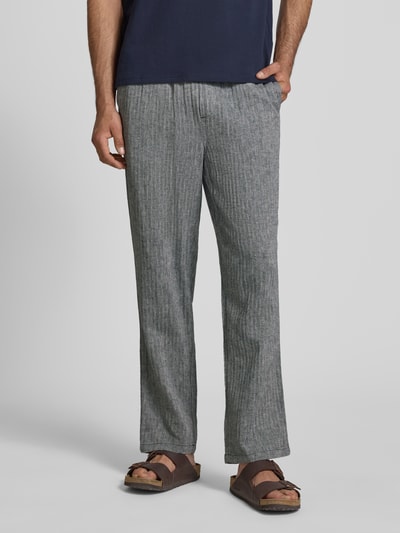Männermodel trägt Hose aus Leinen-Baumwoll-Mix Modell 'MAXIM' von Blend, grau gestreift, Relaxed Fit, elastischer Bund, Nahaufnahme Unterkörper, Produktdetails im Kontext.