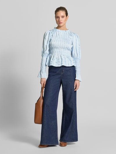 Frauenmodel trägt Bluse in tailliertem Schnitt mit Smok-Details Modell 'RAVA' von YAS, hellblau, Viskose-Mix, Ganzkörperansicht von vorne.
