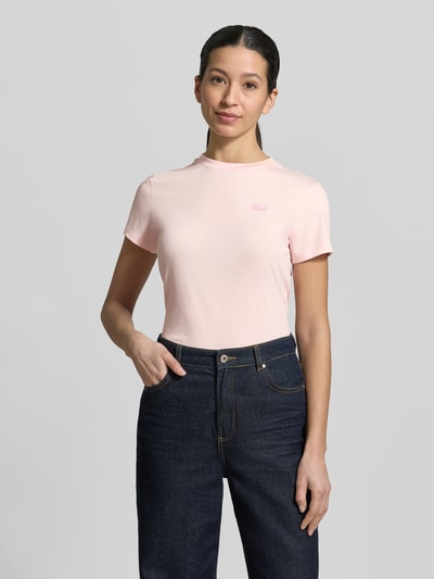 Vrouwenmodel draagt Slim Fit T-shirt uit katoenmix van Lacoste met look: effen, logopatch, ronde hals, Ganzkörperansicht van voren