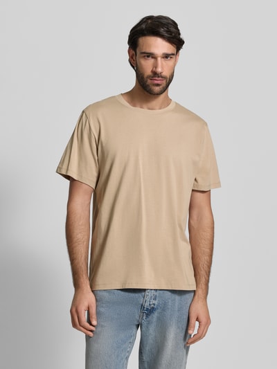 Męski model nosi Regular Fit T-Shirt aus reiner Baumwolle Modell 'ASPAN' od SELECTED HOMME, beżowy, krój regular fit, jersey; całkowity widok z przodu.