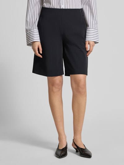 Frauenmodel trägt Schlupfbermuda Techno Cotton Superstretch von Raffaello Rossi in Schwarz, Regular-Fit, Modell ISKA, elastischer Bund, Gesäßtaschen, Bundweite bei Größe 36: 39 cm, Innenbeinlänge bei Größe 36: 24 cm, Ganzkörperansicht von vorne.