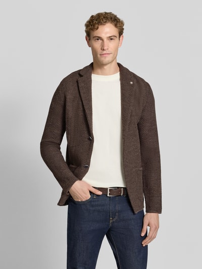 Männermodel trägt Cardigan mit Schurwoll-Anteil in Strick-Optik von Manuel Ritz, braun, aufgesetzte Taschen, Ganzkörperansicht von vorne.