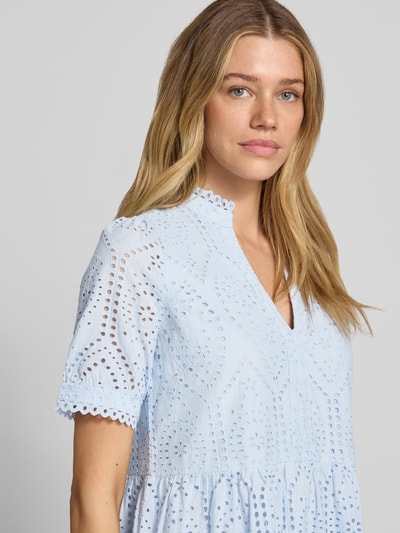 Vrouwenmodel draagt mini-jurk met ajourwerk in lichtblauw van puur katoen, A-lijn, V-hals, model 'Holi' van YAS, detailopname bovenlichaam
