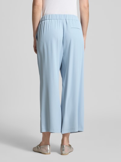 Frauenmodel trägt Stoffhose mit elastischem Bund von Jake*s Collection in Hellblau, Material-Mix mit Stretch-Anteil, weites Bein, gelegte Falten, Ganzkörperansicht Rückansicht.