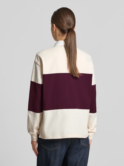 Frauenmodel trägt Regular Fit Sweatshirt aus reiner Baumwolle von GANT in Creme und Dunkelrot, strukturierte Oberfläche, Ganzkörperansicht Rückansicht.