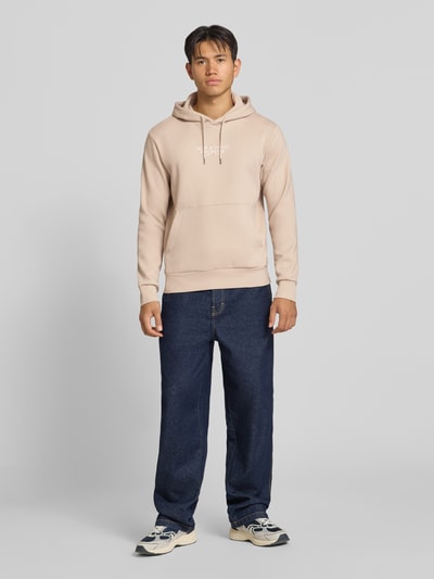 Männermodel trägt Hoodie mit Label-Print Modell 'JPRBLUARCHIE' von JACK & JONES, beige, lockerer Schnitt, Ganzkörperansicht von vorne