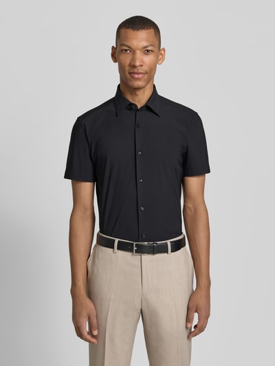 Männermodel trägt Slim Fit Businesshemd mit kurzem Arm Modell 'P-HANK-K-SH-262' von BOSS, unifarben schwarz, Kentkragen, Ganzkörperansicht von vorne