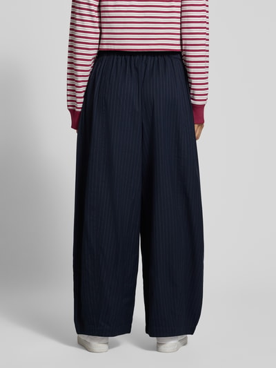 Vrouwenmodel draagt Barrel Fit broek Model 'Bambus' van LOLLYS LAUNDRY, materiaalmix met viscose, all-over look, knoopsluiting, donkerblauw met fijne strepen, bandwijdte maat S 35 cm, binnenbeenlengte 69 cm, volledig zicht van achteren.