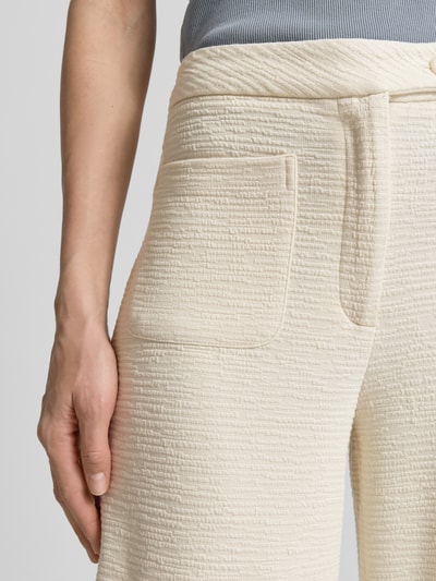 Frauenmodel trägt Hose aus Viskose-Mix mit Strukturmuster Modell 'KATE LUMINA' von ICHI, cremefarben, AufgesetzteTaschen, Nahaufnahme Oberkörper.