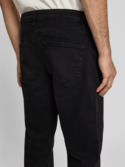 Männermodel trägt Regular Fit Straight Leg Jeans aus Baumwoll-Mix Modell 'WEFT' von Only & Sons in dunkler Denim-Optik, 5-Pocket-Design, Label-Patch, Materialverarbeitung Twill, Nahaufnahme Rückansicht.