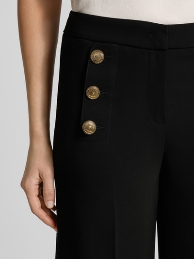 Frauenmodel trägt Stoffhose mit Bundfalten Modell 'BRIDGET' von SEDUCTIVE, schwarzer Material-Mix mit Stretch-Anteil, Detailaufnahme.