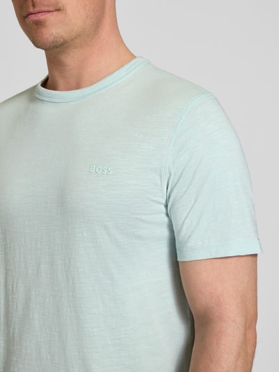 Männermodel trägt Regular Fit T-Shirt aus reiner Baumwolle Modell 'TEGOOD' von BOSS Orange, Optik: Unifarben, Logo-Detail, Nahaufnahme Oberkörper.