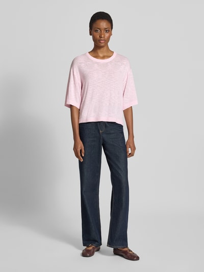 Frauenmodel trägt Relaxed Fit Pullover aus Viskose-Mix Modell 'Vicki' von FREE/QUENT in Rosa mit Rundhalsausschnitt, Stick-Optik, semitransparent, 1/2-Arm, kombiniert mit weiter Jeans, Ganzkörperansicht von vorne.