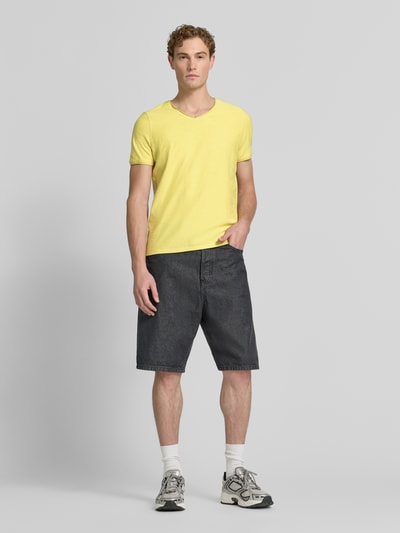 Männermodel trägt T-Shirt mit V-Ausschnitt und Rollsaum von MCNEAL in Gelb, Reine Baumwolle, Regular-Fit, Herren T-Shirt, Ganzkörperansicht von vorne. Rückenlänge bei Größe M: 81 cm.
