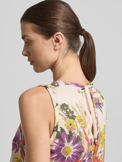 Vrouwenmodel draagt midi-jurk met ronde hals model 'TABARIN' van EMME, puur katoen, loose fit, volantzoom, druppelvormige hals, bloemenprint. Detailopname rugaanzicht.