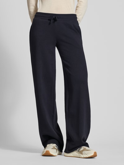 Frauenmodel trägt Wide Fit Sweatpants mit Viskose-Anteil von Review, dunkelblau, elastischer Bund mit Tunnelzug, Baumwoll-Mix, Ganzkörperansicht von vorne.