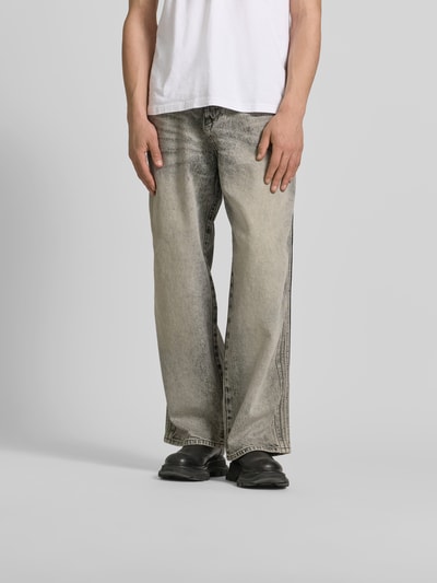 Männermodel trägt Loose Fit Jeans aus Baumwoll-Mix von Diesel in Beige mit 5-Pocket-Design und Label-Detail, Nahaufnahme Unterkörper. Kontext: Herren Jeans aus Baumwoll-Hanf-Mix, Loose-Fit, Knopf-Reißverschluss, Innenbeinlänge 80 cm, Bundweite 44 cm.