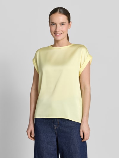 Frauenmodel trägt T-Shirt mit Rundhalsausschnitt Modell 'ELLETTE' von Vila in hellem Gelb, locker geschnitten, Nahaufnahme Oberkörper.