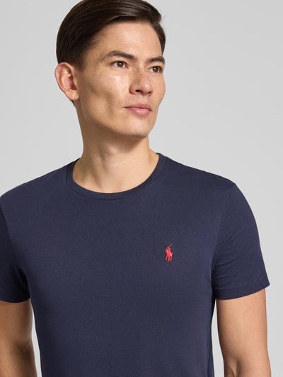 Männermodel trägt T-Shirt mit Label-Stitching von Polo Ralph Lauren in Dunkelblau, reine Baumwolle, Nahaufnahme Oberkörper.