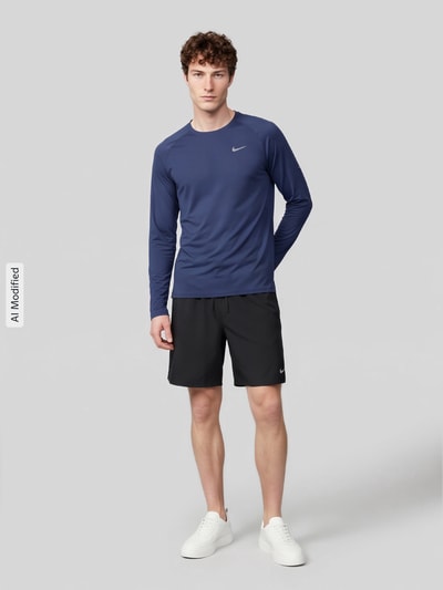 Męski model nosi Regular Fit Sport-Langarmshirt mit Logo-Detail von Nike, kolor granatowy, prosta faktura, Ganzkörperansicht von vorne, KI-modifiziertes Bild. Koszulka sportowa Nike Training.
