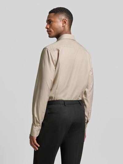 Männermodel trägt Slim Fit Businesshemd aus reiner Baumwolle Modell 'HANK' von BOSS in Beige, strukturierte Piqué-Oberfläche, Ganzkörperansicht Rückansicht.