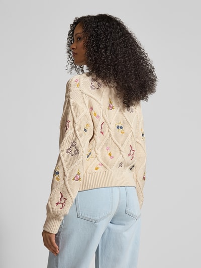 Frauenmodel trägt Regular Fit Strickjacke aus reiner Baumwolle von Jake*s Casual in Beige mit floralem Strukturmuster, Ganzkörperansicht Rückansicht.