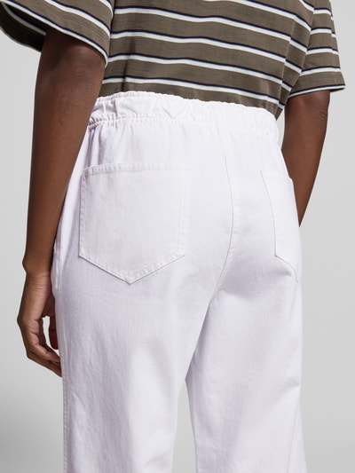 Frauenmodel trägt Wide Fit Stoffhose mit Eingrifftaschen von Juvia aus reiner Baumwolle in Weiß, elastischer Bund mit Tunnelzug, Ganzkörperansicht Rückansicht.