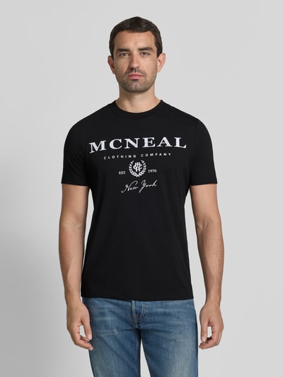 Męski model nosi T-Shirt mit Label-Print und Rundhalsausschnitt von MCNEAL, bawełna, krój regular fit, czarny, długość tyłu 68 cm, Ganzkörperansicht z przodu.