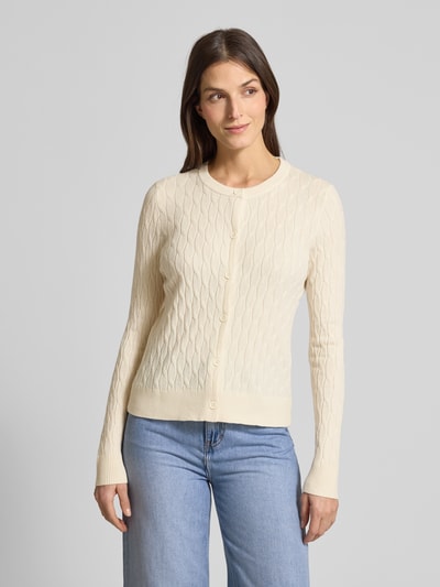 Modelka kobieca nosi Regular Fit Strickjacke mit Viskose-Anteil Modell 'FANTASTIC' od Vero Moda, kremowy kolor, wzór warkoczowy, dzianina, przód, ujęcie całej sylwetki z przodu.