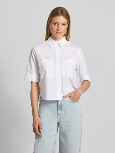 Frauenmodel trägt weiße Boxy Fit Kurzarmbluse aus Baumwoll-Lyocell-Mix von s.Oliver RED LABEL, schlichte Struktur, Ganzkörperansicht von vorne.