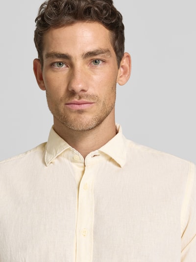 Männermodel trägt Regular Fit Business-Hemd aus Leinen-Baumwoll-Mix Modell 'ROMA' von FIL NOIR, hellbeige, Knopfleiste, Haifischkragen, Nahaufnahme Oberkörper.