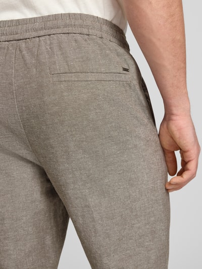 Männermodel trägt Tapered Leinenhose aus Baumwoll-Leinen-Mix Modell 'LINUS' von Only & Sons in Melange-Optik, Nahaufnahme Rückansicht.