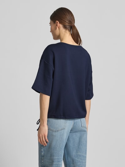 Frauenmodel trägt Relaxed Fit T-Shirt mit Logo-Print von Christian Berg Woman, Dunkelblau, Elastischer-Material-Mix mit Modal-Anteil, Rundhalsausschnitt, Ganzkörperansicht Rückansicht.