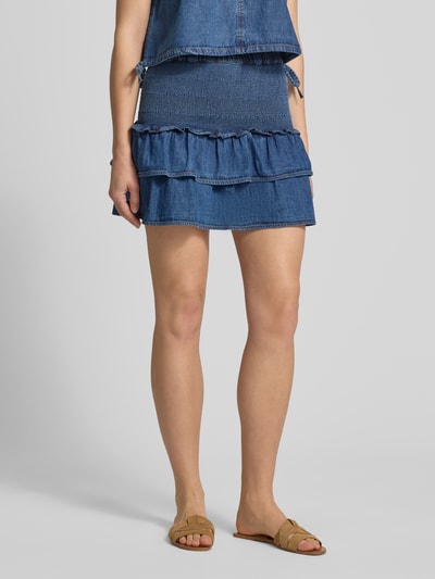 Frauenmodel trägt Denim Minirock aus reiner Baumwolle mit Volants von Tommy Jeans, blaue Crinkle-Optik, elastischer Bundabschluss, körpernahe Passform, Ganzkörperansicht von vorne.