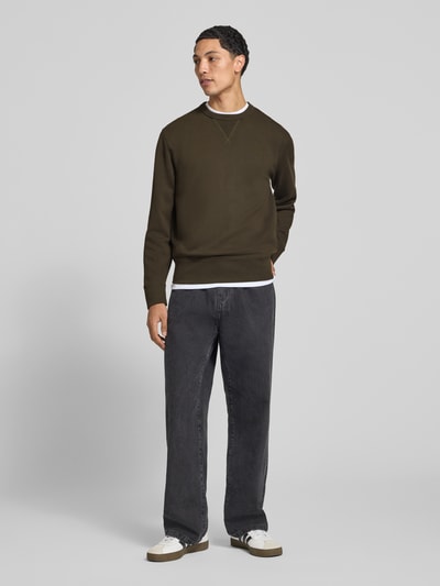 Männermodel trägt Sweatshirt aus Baumwoll-Mix von Superdry in Dunkelgrün, lockere Passform, Rundhalsausschnitt, Ganzkörperansicht von vorne.