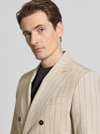 Männermodel trägt Slim Fit Sakko mit Reverskragen Modell 'Phinix' von CG - Club of Gents, beige mit feinen Streifen, Nahaufnahme Oberkörper.