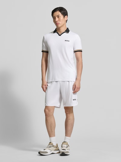 Männermodel trägt Relaxed Fit Sport-Shorts mit Logo-Print Modell 'SH_TOC SPIN 9 INCH' von BOSS Green, Optik: Unifarben, Kontraststreifen, Tunnelzug, elastischer Beinabschluss, seitliche Eingrifftaschen, Ganzkörperansicht von vorne.