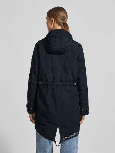 Kobiece modelka nosi Kurtka 'Jacke mit Ärmelriegeln' od NAUTGÅRD, krój regular fit, kaptur z tunelem, listwa guzikowa, kieszenie zapinane na zamek błyskawiczny, patki przy mankietach, długość tyłu w rozmiarze S: 90 cm, szerokość ramion w rozmiarze S: 45 cm, szerokość klatki piersiowej w rozmiarze S: 51 cm, długość rękawów w rozmiarze S: 62 cm, kolor ciemnogranatowy, prosty fason, gładka tekstura, całkowity widok z tyłu.