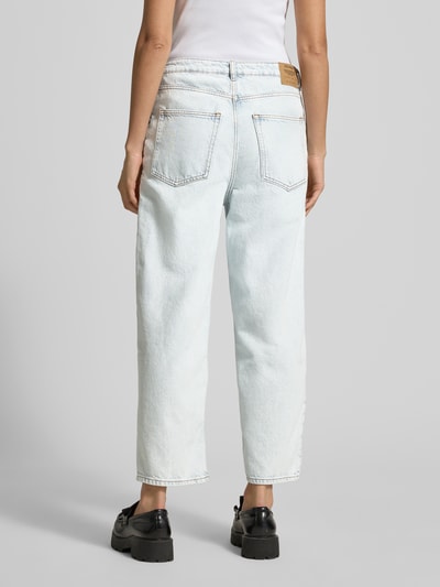 Frauenmodel trägt Straight Fit Jeans im 5-Pocket-Design Modell 'Joybird' von American Vintage aus reiner Baumwolle, hellblaue Farbe, grobe Textur, Ganzkörperansicht Rückansicht.