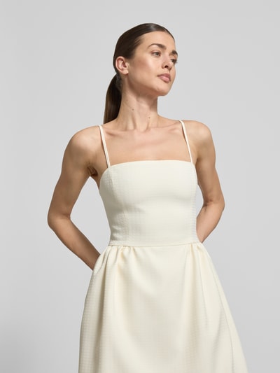Modelka kobieca nosi tailliertes Cocktailkleid mit Viskose-Anteil Modell 'Kejani' od HUGO, kremowy, strukturalny materiał, krótka długość, naramki spaghetti, karczek kwadratowy, sukienka mini, widok górnej części ciała z przodu.