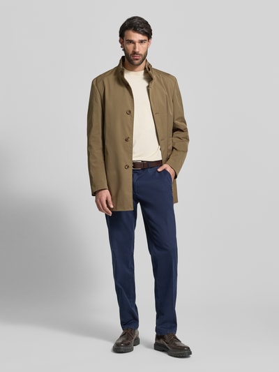 Männermodel trägt Mantel mit durchgehender Knopfleiste von CINQUE in Beige, gerade Passform, Stehkragen mit Riegel, Eingrifftaschen, Ganzkörperansicht von vorne. Rückenlänge 83 cm, Schulterbreite 42 cm, Brustweite 40 cm, Ärmellänge 66 cm bei Größe 50.