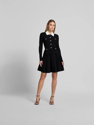 Frauenmodel trägt Minikleid aus Viskose-Mix von Self-Portrait in Schwarz mit Strick-Optik, Ziersteinbesatz, Slim Fit, Ganzkörperansicht von vorne.