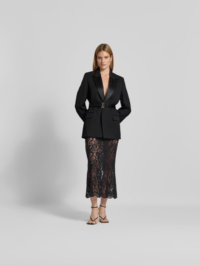 Frauenmodel trägt schwarzen Blazer mit Schurwoll-Anteil von Victoria Beckham, taillierte Passform, Reverskragen, Taillienband, Ganzkörperansicht von vorne