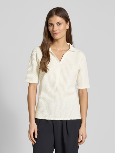 Frauenmodel trägt Regular Fit Poloshirt mit V-Ausschnitt von Betty Barclay aus Baumwoll-Mix mit Stretch-Anteil, Strukturmuster, Ganzkörperansicht von vorne.