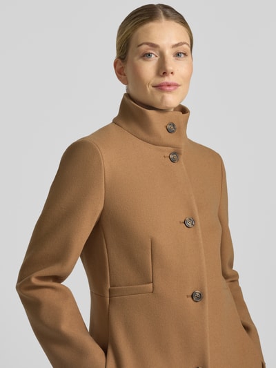 Frauenmodel trägt Mantel mit Woll-Anteil und Stehkragen von CINQUE in Camel, glatte Textur, Knopfleiste, Nahaufnahme Oberkörper. Material-Mix und Straight Fit erkennbar, seitliche Eingrifftaschen sichtbar, Schulter- und Brustweite passen zur angegebenen Größe 36.