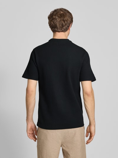Männermodel trägt Regular Fit T-Shirt aus Baumwoll-Mix Modell 'TOBIE' von Only & Sons, unifarben, Waffel-Struktur, Ganzkörperansicht Rückansicht.