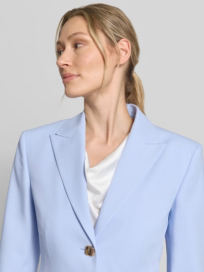 Vrouwenmodel draagt Regular Fit Blazer met Zierknöpfe Modell 'ASMALLA' van HUGO in effen lichtblauw twill, gouden knopen, detailopname bovenlichaam.
