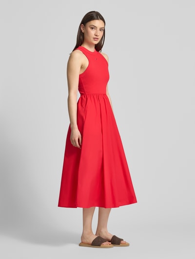 Frauenmodel trägt Midikleid aus reiner Baumwolle von Tommy Jeans, Optik: Unifarben, Passform: A-Linie, Länge: Midi, Rundhals, ohne Ärmel, Ganzkörperansicht von vorne.