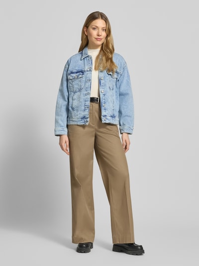 Kobiece model prezentuje Regular Fit Jeansjacke aus Baumwoll-Mix Modell 'TESSA' von Vero Moda, efekt: jednolity kolor, wykładany kołnierz, listwa guzikowa, wyhaftowane logo, pas na plecach, patka, karczek, długi rękaw, mankiet, kieszenie na piersi, wpuszczane kieszenie, wykończenie materiału: denim, mieszanka bawełny, Ganzkörperansicht von vorne.